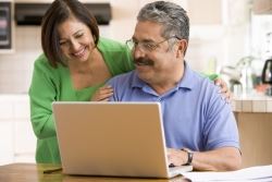 A couple happily planning their estate at home on a laptop